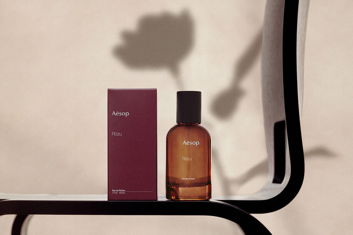 rozu perfume in a bottle on a chair designed by Charlotte Perriand